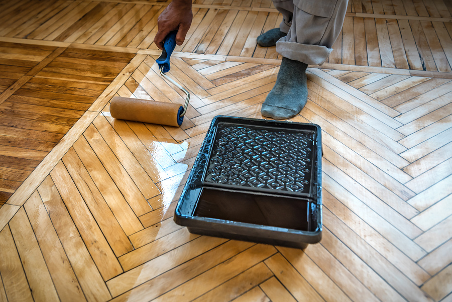 Lacquering wood floors. Use roller for coating floors.
